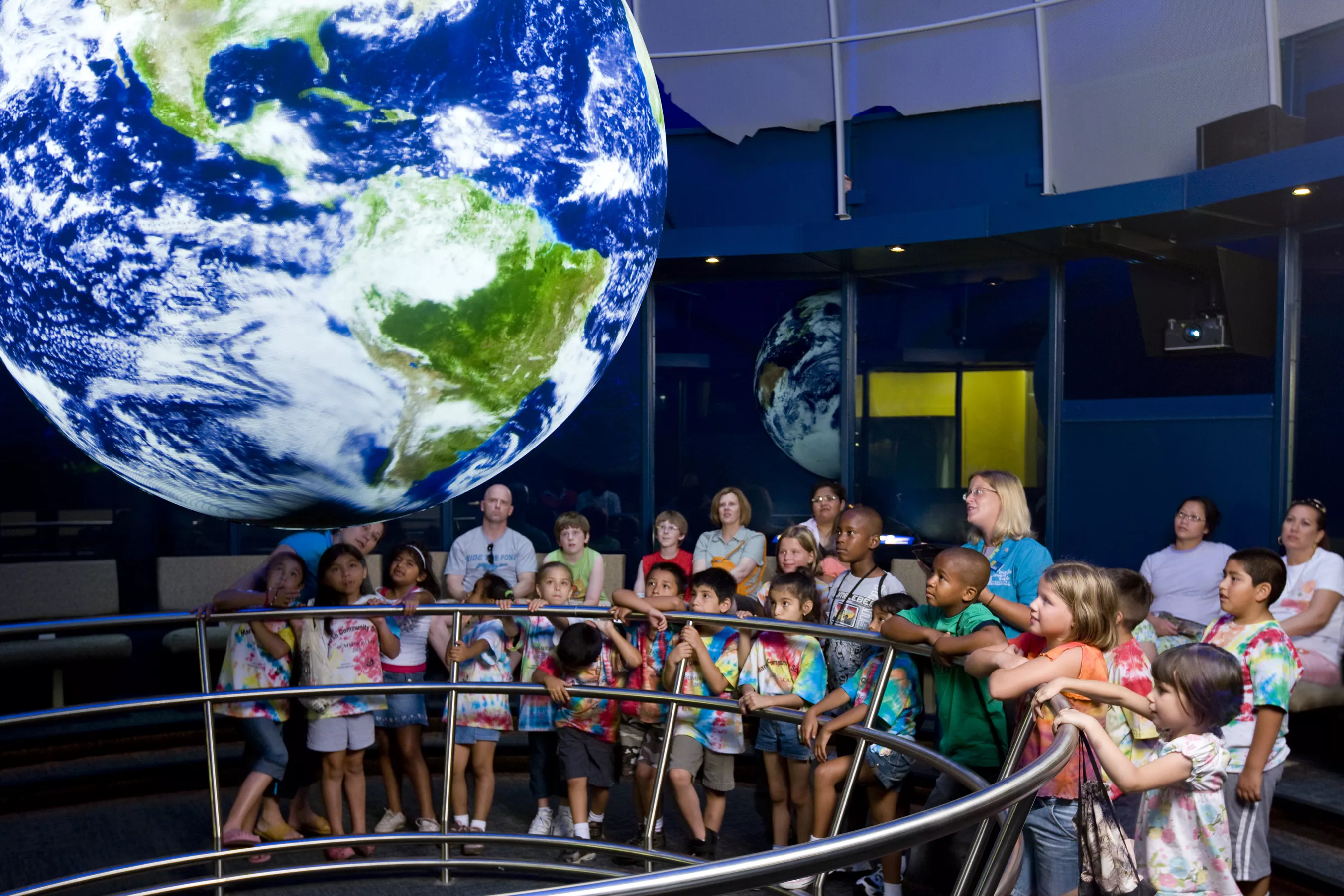 A group of children watches a Science on a Sphere presentation. 