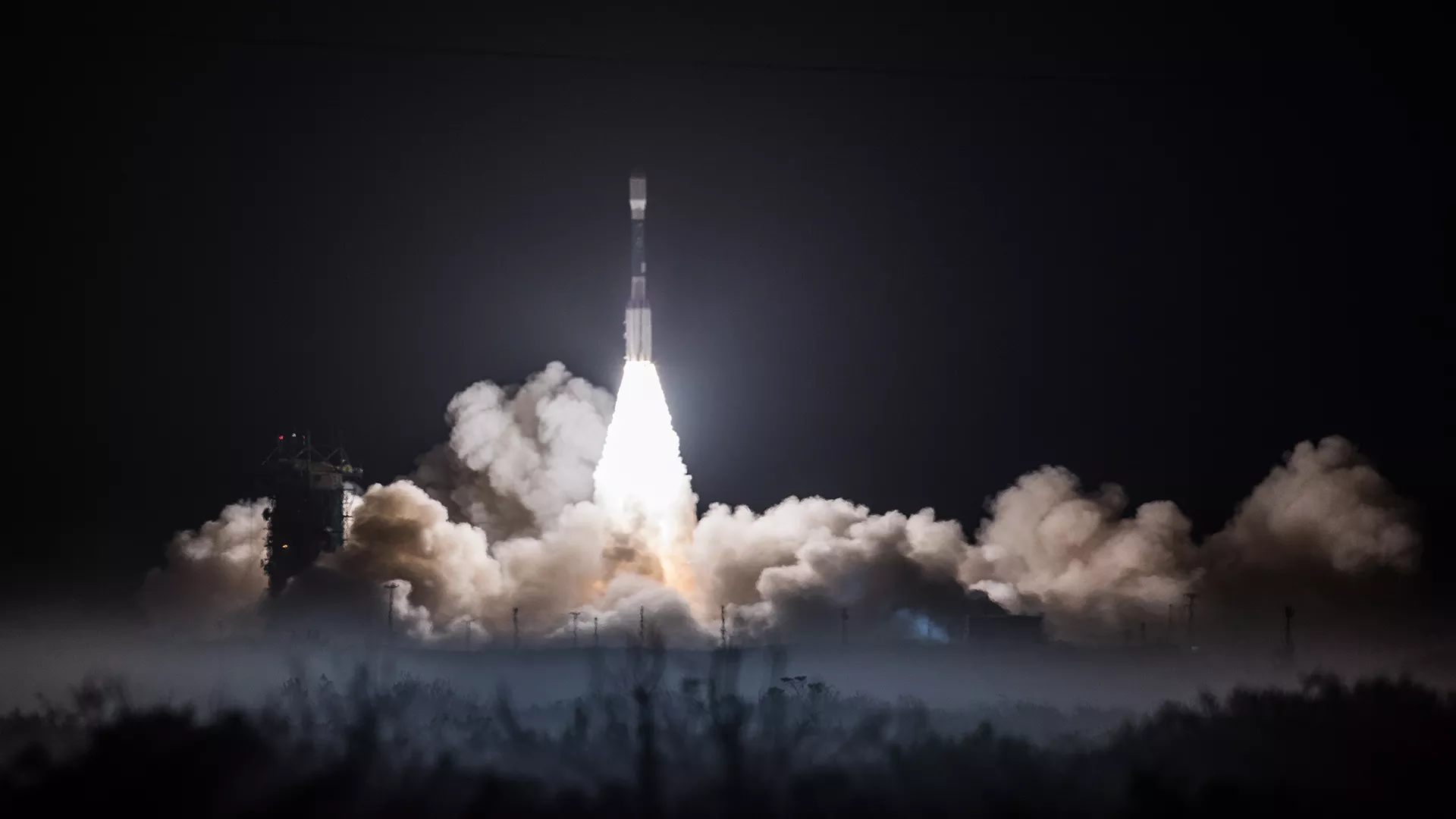 Image of JPSS-1 Satellite taking off from the launch pad on a rocket at night.